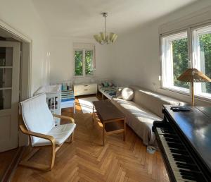 a living room with a couch and a piano at Zongorás Apartman in Balatonalmádi