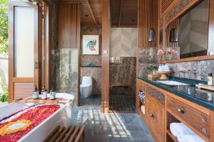 a bathroom with a tub and a sink and a toilet at Dijero at Umah Bali in Ubud