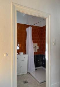 a bathroom with a shower with a white shower curtain at Zongorás Apartman in Balatonalmádi