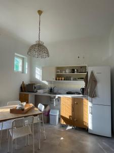 a kitchen with a table and a white refrigerator at Zongorás Apartman in Balatonalmádi +15 photos