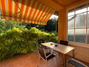 a wooden table and chairs on a patio with a window at Zongorás Apartman in Balatonalmádi
