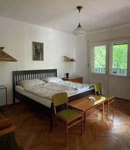 a bedroom with a bed and a table and chairs at Zongorás Apartman in Balatonalmádi