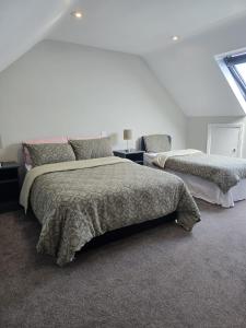 a white bedroom with two beds and a window at Cope House Rooms in Killybegs