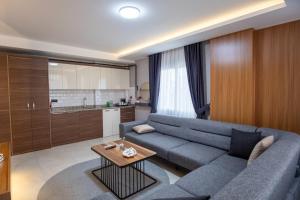 a living room with a blue couch and a kitchen at Gala Mtm Konaklama in Çiftlikköy +37 photos