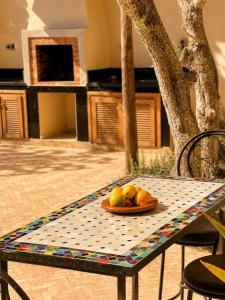 a table with a plate of fruit on it at Maison Zina in Al Ghar