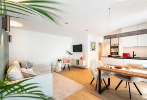 a living room and kitchen with a table and chairs at Nomes Apartment in Axams