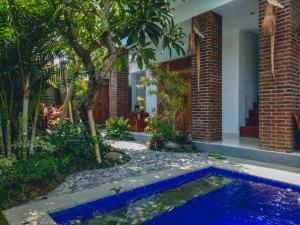 a swimming pool in a garden with a house at The Ambara Bali in Canggu