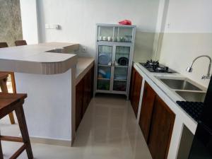 a kitchen with a sink and a dishwasher at The Ambara Bali in Canggu