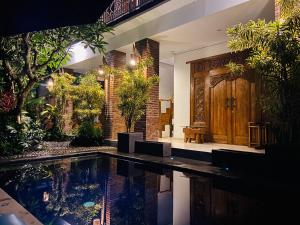 a swimming pool in front of a house at The Ambara Bali in Canggu +8 photos