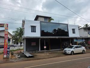 a white car parked in front of a building at Ruby Residency in Perintalmanna