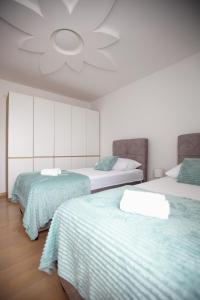 a bedroom with two beds and a ceiling at Ana & Marija in Kaštela