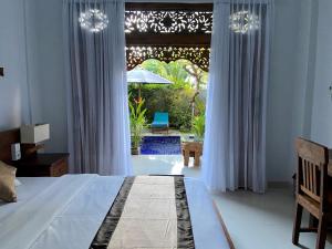 a bedroom with a bed and a large window at The Ambara Bali in Canggu