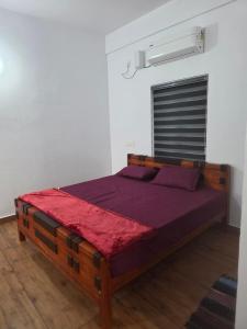 a bedroom with a large bed with purple sheets at Ruby Residency in Perintalmanna