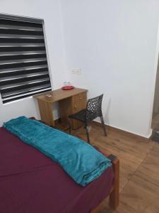 a bedroom with a desk and a bed and a chair at Ruby Residency in Perintalmanna