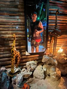 a man standing in front of a picture of a giraffe at Tipiland baru la casa del mono in Playa Blanca