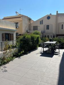 a patio with a table and chairs in front of a building at Luminous Home in Vari