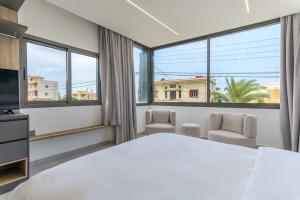 a bedroom with a large bed and windows at Cavella Apart Hotel in Monsef in Al Ḩulwah