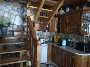 a kitchen with wooden cabinets and a spiral staircase at Agroturystyka Ela in Rzepiska