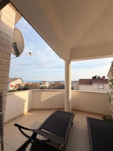 a balcony with a chair and a view of the ocean at TIMO Apartment Split Croatia in Kaštela