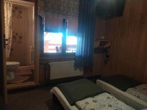 a bedroom with a window and a bed and a toilet at Agroturystyka Ela in Rzepiska
