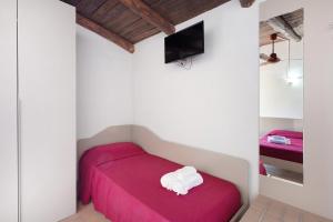 a bedroom with a red bed and a tv at Tenuta Donna Carmela in Pisciotta