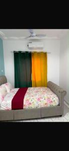 a bed with colorful curtains in a bedroom at Brufut Residencies Apartment 5 in Brufut