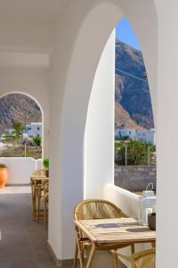 a patio with tables and chairs with mountains in the background at Santana Apartments in Perivolos