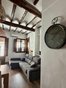 a living room with a couch and a clock on the wall at Cal Padrí in Caseras