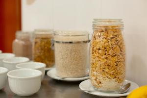 a table topped with jars of granola on plates at Hotel Caminho do Rosário in Aparecida +33 photos
