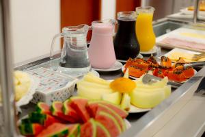 a buffet of food with fruits and drinks on a table at Hotel Caminho do Rosário in Aparecida