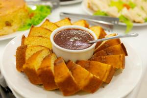 a plate of food with a bowl of dipping sauce at Hotel Caminho do Rosário in Aparecida