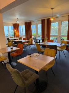 a restaurant with tables and chairs and windows at Sure Hotel by Best Western Limoges Sud in Feytiat