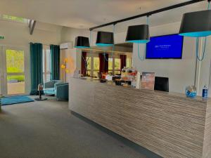 a restaurant with a counter with blue lights at Sure Hotel by Best Western Limoges Sud in Feytiat
