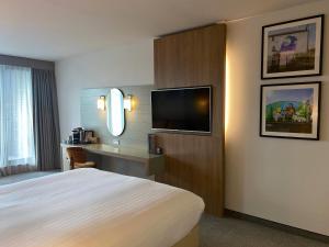 a hotel room with a bed and a flat screen tv at Absolute Hotel Limerick in Limerick