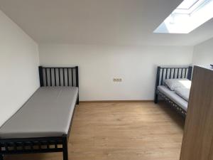 ein Schlafzimmer mit zwei Betten und Holzboden in der Unterkunft 3 Elementy in Čachtice