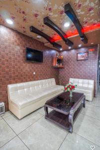 a living room with two white couches and a table at Hotel Crown Plaza in Hoshiārpur