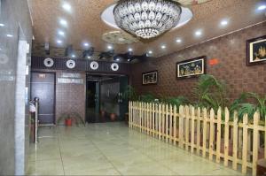 a lobby with a large chandelier in a building at Hotel Crown Plaza in Hoshiārpur