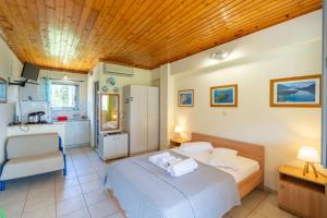 a bedroom with a bed and a kitchen at Matina Studios in Nikiana