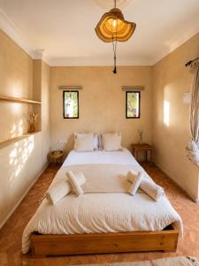 a bedroom with a large bed with white sheets and pillows at Maison Zina in Al Ghar +108 photos