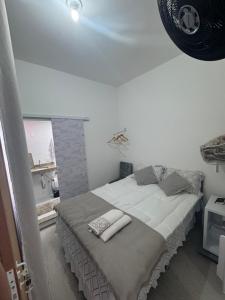 a white bedroom with a bed with towels on it at Ebeneze in Nova Friburgo