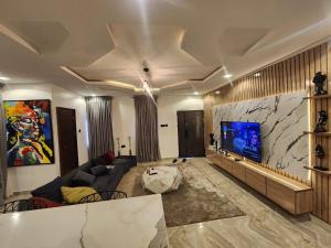 a living room with a couch and a flat screen tv at OSOJAPA Residence in Asaba