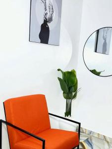 an orange chair in a room with a mirror at OSOJAPA Residence in Asaba