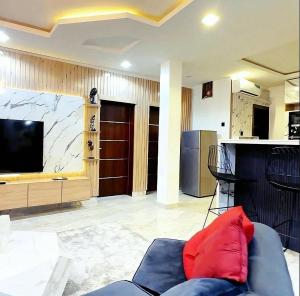 a living room with a couch and a large television at OSOJAPA Residence in Asaba