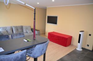 a living room with a couch and a red table at Merķeļa apartamenti in Valka +6 photos