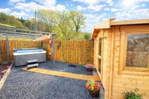 a backyard with a hot tub next to a wooden fence at Dolgun Uchaf Historic B&B and Cottages with Boutique Bedrooms In The Heart of Snowdonia in Dolgellau