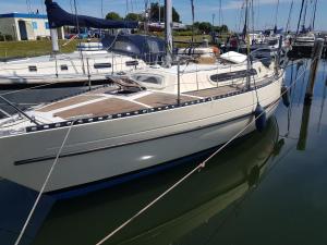 a white boat is docked in the water at Boots-Camping Grevelingen in Herkingen