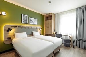 ein Hotelzimmer mit zwei Betten und einer grünen Wand in der Unterkunft Campanile PRIME - Wroclaw Stare Miasto in Breslau