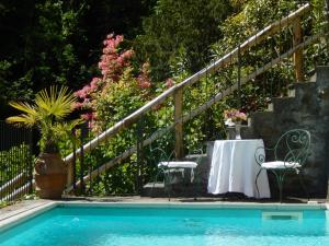 a pool with a table and chairs next to a fence at Villa Zanotti in Cannero Riviera