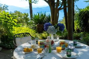 a table with plates of food and drinks on it at Villa Zanotti in Cannero Riviera