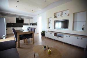 a living room with a dining table and a kitchen at Ana & Marija in Kaštela